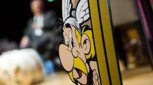 epa04974836 A picture of cartoon character Asterix is displayed during a press conference presenting the 36th album of the adventures of the two Gauls entitled 'Le Papyrus de Cesar' (Cesar's Papyrus) at the Eiffel Tower in Paris, France, 12 October 2015. This album will be released worldwide on 22 October. This is the second album created by French cartoonist Didier Conrad and scenarist Yves Ferri.  EPA/ETIENNE LAURENT