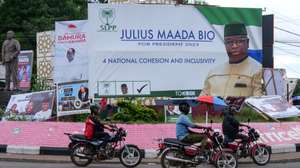 epa10708396 Motorcyclists ride past elections campaign banners in Freetown, Sierra Leone, 23 June 2023. Over three million Sierra Leoneans citizens are expected to cast their votes in a general election on 24 June 2023 in which incumbent President Julius Maada Bio is seeking a second and final term.  EPA/IBRAHIM BARRIE