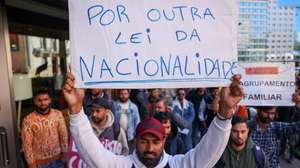 epa12015245 A protester holds a banner 'In defence of another nationality law' during a protest against the discrimination and lack of answers from Agency for Integration, Migration and Asylum (AIMA) in Lisbon, Portugal, 07 April 2025. The initiative, supported by Portugal’s largest immigrant association, Solidariedade Imigrante, reflects the concerns of immigrants over recent legal reforms that abolished the ‘expression of interest’ — a legal resource that allowed the legalisation of foreigners only with a tourist visa.  EPA/MIGUEL A. LOPES