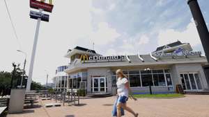 epa04327485 An Ukrainian woman carrying her shopping bag while passing a closed and deserted McDonalds restaurant in the city of  Donetsk, Ukraine, 23 July 2014. The restaurant was closed, and a part of the space is now used for a small grocery store. Donetsk, which is controlled by separatist forces, has become the capital of 'Donetsk People's Republic' (DNR). A 'People's Council' now rules there and the surrounding region, with a population of 4.5 million.  EPA/ROBERT GHEMENT
