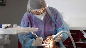 epa08416579 Dentist Alexandra Smooth, wears personal protect equipement, due to the coronavirus pandemic, as she works on a patient at her practice in Gignac, France, 12 May 2020. According to media reports, on 11 May 2020, France began to ease coronavirus restrictions, after 55 days of total lockdown.  EPA/GUILLAUME HORCAJUELO