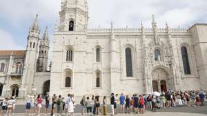 Turistas aguardam pela entrada na Igreja do Mosteiro dos Jerónimos, em virtude da greve de trabalhadores dos museus e monumentos nacionais, em Lisboa, 15 de agosto de 2025. Convocada pela Federação Nacional dos Sindicatos dos Trabalhadores em Funções Públicas e Sociais, o protesto visa exigir a "justa compensação" do trabalho prestado em dias feriados e também do trabalho suplementar. ANTÓNIO PEDRO SANTOS/LUSA