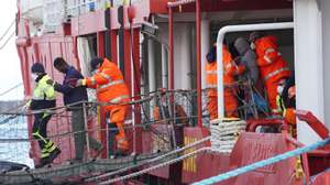 epa10451117 People are helped disembark the Sea-Eye 4 rescue ship after it docked with 106 migrants onboard at the port of Naples, Italy, 06 February 2023. The vessel was expected to dock at the port of Pesaro but was finally authorized to let disembark its passengers in Naples due to rough sea conditions.  EPA/CESARE ABBATE