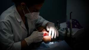 Uma dentista durante um tratamento a um rapaz na clínica “O Sol” que oferece tratamento dentário gratuito a crianças até aos 18 anos, Lisboa, 19 de março de 2025. A 20 de Março comemora-se o Dia Mundial da Saúde Oral.  (ACOMPANHA TEXTO DE 20-03-2025) ANTÓNIO PEDRO SANTOS/LUSA