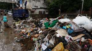 epa11581183 A truck collects trash washed up to a bridge due to a swollen creek and flood current in Antipolo, Rizal province, about 40 kilometers east of Manila, Philippines, 03 September 2024. According to a report by the National Disaster Risk Reduction and Management Council (NDRRMC) on 03 September, at least ten people have died, ten have been injured, and thousands of residents left their homes due to flooding in the wake of Typhoon Yagi.  EPA/ROLEX DELA PENA