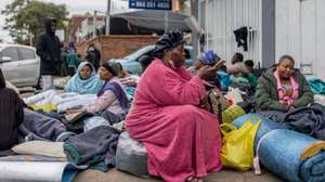 epa13075201 Migrant workers shelter outside a Home Affairs building during a nationwide anti-immigrant movement shutdown in Durban, South Africa, 30 June 2026. Marches are planned across South Africa as a large number of organizations under the umbrella of the 'March and March movement' take to the streets of major cities to protest against the high number of legal and illegal immigrants living in the country. Although the protesters issued an ultimatum demanding that foreign nationals leave South Africa by 30 June, the South African government has explicitly rejected the shutdown and declared June 30 a normal working day.  EPA/STRINGER