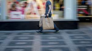 Um homem carrega sacos de compras no primeiro dia de reabertura das lojas em Praga, República Checa, 10 de maio de 2021