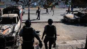 epa11200677 Police guard the exterior of the Carrefour Aeroport police station, which was set on fire on 04 March by gang members, in Port-au-Prince, Haiti, 05 March 2024. The streets of Port-au-Prince show apparent normality after the intense shootings the day before, although in some places bodies continue to appear. The population tries to recover normality and dedicates themselves to their daily tasks, despite the fact that on their way, as EFE was able to verify, they come across corpses that some people cover with a blanket, while others are simple charred remains.  EPA/JOHNSON SABIN