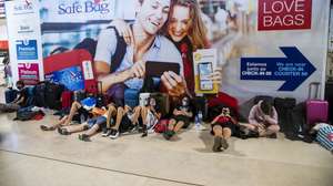Passengers lay on the floor as they wait for their flight due to a strike of the handling company, Groundforce, which is causing major disruption in the Lisbon Airport, causing the cancelation of dozens of flights, in Lisbon, Portugal, 17 July 2021. Groundforce workers are protesting against colective dismissal of workers and low salaries. JOSE SENA GOULAO/LUSA