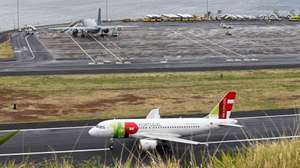 epa07517096 A TAP Airbus A319 airplane (bottom) takes off as persons injured in the 17 April bus crash are boarded onto a German air force airplane (top) to to be flown to Germany, from the airport oif Funchal, Madeira island, Portugal, 20 April 2019. At least 29 German tourists were killed after a bus crashed at the site on Madeira island on 17 April 2019.  EPA/HOMEM GOUVEIA