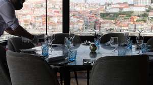 Um funcionário prepara uma mesa no restaurante The Blini no dia em que entram em vigor novas medidas de desconfinamento, Vila Nova de Gaia, 19 de abril de 2021. Passa a ser autorizada a abertura de restaurantes, cafés e pastelarias, mas com a restrição de lotação máxima a quatro pessoas ou seis pessoas em esplanadas e com horário até às 22:00 horas ou às 13:00 ao fim de semana. JOSÉ COELHO/LUSA