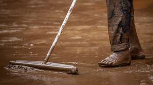 epa09679436 A man cleans mud from the floods caused by heavy rains in Sabara, Minas Gerais state, Brazil, 11 January 2022. At least 10 people died and a hundred more had to leave their homes in the last 24 hours, due to the heavy rains that hit the Minas Gerais region, the second state most affected by downpours in Brazil in recent weeks, reported the Civil Defense.  EPA/Thomas Santos
