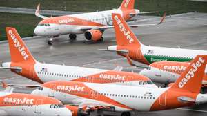 epa08788642 The first plane arriving, an EasyJet plane (back), taxiing on the tarmac during the opening of BER Berlin Brandenburg Airport in Schoenefeld, Germany, 31 October 2020. The opening of BER airport on 31 October 2020 is planned with the arrival of two first passenger planes by companies Lufthansa and EasyJet.  EPA/CLEMENS BILAN / POOL