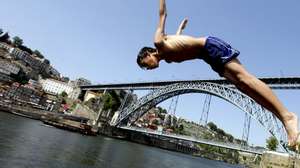 Um rapaz salta para o rio Douro no Porto, 31 de maio de 2012. Temperaturas elevadas na cidade do Porto levaram crianças a tomar banho no rio Douro. JOSE COELHO / LUSA