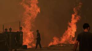 Residentes protegem as suas habitações do incêndio em Covelo, Gondomar, 17 de setembro de 2024. Desde domingo, as chamas chegaram aos distritos do Porto, em Gondomar, de Braga, em Cabeceiras de Basto, de Viseu, em Penalva do Castelo e Nelas (com seis feridos), e de Castelo Branco, em Louriçal do Campo. Mas foi o distrito de Aveiro, com 10 mil hectares já ardidos, o centro dos maiores focos de incêndio, em Oliveira de Azeméis, Sever do Vouga, Albergaria-a-Velha e Águeda. JOSÉ COELHO/LUSA