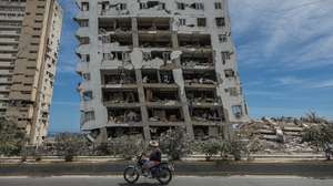 epa13070939 A person walks past a building destroyed by the earthquakes in Catia La Mar, Venezuela, 28 June 2026. Venezuelan National Assembly President Jorge Rodriguez said at least 1,430 people were killed after two powerful earthquakes struck the country on 24 June. Authorities have restricted access to some disaster zones and deployed the military as relief efforts continue.  EPA/Henry Chirinos
