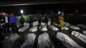 epa13107675 Thai Prime Minister Anutin Charnvirakul (3-L) inspects the situation next to fire victims' bodies outside the burned pub in Bangkok, Thailand, early on 13 July 2026. At least 27 people were killed after a fire engulfed the bar, according to Anutin.  EPA/RUNGROJ YONGRIT