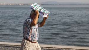 Um homem protege-se do calor com um saco de papel junto ao rio tejo esta tarde em Lisboa, 03 de setembro de 2026. distritos estão sob aviso amarelo hoje e amanhã devido à previsão e tempo quente, com valores elevados da temperatura máxima, segundo o Instituto Português do Mar e Atmosfera (IPMA). MIGUEL A. LOPES/ LUSA