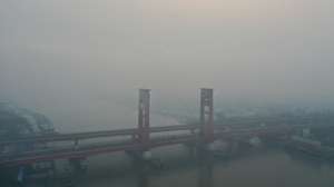epa13216250 An aerial view taken with a drone shows thick haze from wildfires shrouding Ampera Bridge in Palembang, South Sumatra, Indonesia, 06 September 2026. Wildfires in Sumatra and Kalimantan, intensified by strong El Nino conditions, have generated widespread smoke haze that has spread across the region, causing hazardous air quality in neighboring Malaysia, Singapore and the Philippines.  EPA/MAST IRHAM