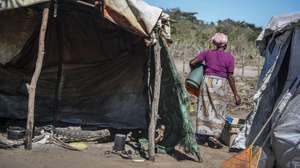 Uma residente caminha entre abrigos provisórios na comunidade de reassentamento de Nsime, na Katembe, província de Maputo, Moçambique, 17 de agosto de 2026. Cerca de 100 famílias afetadas pelas cheias de 2023 foram transferidas para a localidade, onde procuram reconstruir as suas vidas antes do início de uma nova época chuvosa. (ACOMPANHA TEXTO DA LUSA DO DIA 12 DE OUTUBRO DE 2026.) LINA CEBOLA/LUSA