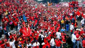 epa00807035 Supporters of Venezuelan President Hugo Chavez (arriving in a bus on the top-right) greet their leader on Friday, 01 September 2006 in Caracas, Venezuela. This was the first big electoral campaign event organized. Chaves is seeking re-election in the December elections.  EPA/Chico Sanchez