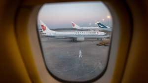 epa10338794 An aircraft ground personnel wearing a protective suit looks on an Air China airplane at the Beijing Capital International Airport in Beijing, China, 30 November 2022. According to the National Health Commission, China has reported 37,828 new COVID-19 cases on 29 November, slight drop than a day earlier, of which 1,282 new locally transmitted cases were detected in Beijing, as the country continues to contain outbreaks in several cities such as Guangzhou and Chongqing in the south.  EPA/MARK R. CRISTINO