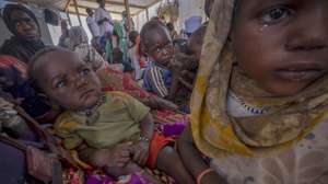epa11264107 Sudanese refugees sit in a makeshift tent in the Adre transition camp, on the border with Sudan in Adre, Chad, 05 April 2024 (issued 07 April 2024). Since the war in Sudan began, more than 650,000 people have taken refuge in Chad. While the UN warns that Sudan is on the verge of the worst hunger crisis in decades, cases of malnutrition are identified among refugee minors in Chad. For this reason, the Doctors Without Borders' team practices a protocol for all the minors who pass through its clinic in the Adre camp and treats those with cases of malnutrition and refers those with severe malnutrition to the hospital.  EPA/Ricardo Garcia Vilanova