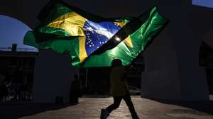 epa13025293 A boy runs with the Brazilian flag during a barber competition in Rio de Janeiro, Brazil, 08 June 2026. The Brazilian city of Rio de Janeiro hosted an international barber competition in which professionals showcased the latest haircut trends, many of which were inspired by the upcoming 2026 FIFA World Cup.  EPA/ANTONIO LACERDA