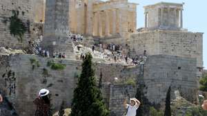 epa12200837 Tourists pose for photos in front of the Acropolis amid a heatwave in Athens, Greece, 27 June 2025. Very high maximum temperatures are expected, in places over 40 degrees Celsius, on 27 June, according to the latest forecast data from the National Observatory of Athens.  EPA/ALEXANDROS VLACHOS