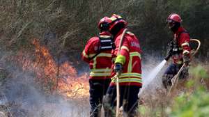Bombeiros combatem o incêndio florestal que deflagrou ao final da tarde de segunda-feira em Rebordões, no concelho de Santo Tirso, em Burgães, 18 de agosto de 2026. ESTELA SILVA/LUSA