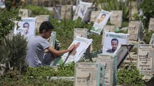 epa13277436 A person cleans the portrait on the grave of a relative at a cemetery dedicated to those who were killed in Yemen's prolonged conflict, in Sana'a, Yemen, 02 October 2026. Yemen has been at risk of rupture again amid escalating fighting along the country’s Red Sea coastal areas near the Bab al-Mandeb Strait between Saudi-backed government forces and the Houthis, who have consolidated their grip over large parts of northern Yemen, including the capital Sana'a, since 2015.  EPA/YAHYA ARHAB