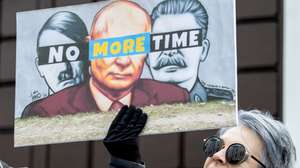 epa11226114 A woman holding a placard depicting (L-R) Adolf Hitler, Russian President Putin and Joseph Stalin protests in front of the Russian Embassy in Chisinau, during Russia presidential elections, in Moldova, 17 March 2024. The Russian Federation Council has scheduled presidential elections for 17 March 2024. Voting will last three days: March 15, 16 and 17. Four candidates registered by the Central Election Commission of the Russian Federation are vying for the post of head of state: Leonid Slutsky, Nikolai Kharitonov, Vladislav Davankov and Vladimir Putin.  EPA/DUMITRU DORU