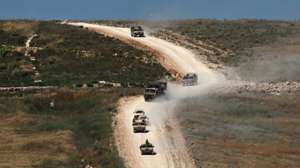 epa13046528 Israeli military vehicles maneuver on the Lebanese side of the border, as seen from the Upper Galilee in northern Israel, 18 June 2026.  EPA/ATEF SAFADI