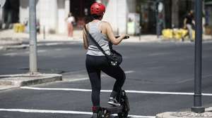 Uma mulher circula numa trotinete na Praça de Londres, em Lisboa, 14 de agosto de 2025. ANTÓNIO PEDRO SANTOS/LUSA