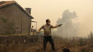 Residentes protegem as suas habitações do incêndio em Covelo, Gondomar, 17 de setembro de 2024. Desde domingo, as chamas chegaram aos distritos do Porto, em Gondomar, de Braga, em Cabeceiras de Basto, de Viseu, em Penalva do Castelo e Nelas (com seis feridos), e de Castelo Branco, em Louriçal do Campo. Mas foi o distrito de Aveiro, com 10 mil hectares já ardidos, o centro dos maiores focos de incêndio, em Oliveira de Azeméis, Sever do Vouga, Albergaria-a-Velha e Águeda. JOSÉ COELHO/LUSA