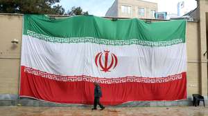 epa12667188 A huge Iranian national flag hangs from the wall of a mosque which was damaged by fire during recent anti-government protests, in Tehran, Iran, 21 January 2026. Iran is experiencing a nationwide internet blackout that began on 08 January 2026, amid an intensifying wave of anti-government protests.  EPA/ABEDIN TAHERKENAREH