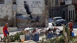 epa12849149 People walk past rubbish accumulating in the streets of Havana, Cuba, 25 March 2026. The Caribbean nation has been experiencing a severe crisis since mid-2014, which has deepened with the oil embargo imposed by the US government since January 2026. The United Nations (UN) has described the US measures as 'actions that violate human rights.'  EPA/ERNESTO MASTRASCUSA