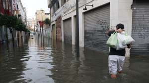 epa13313480 A person wades throught a flooded street after heavy rainfall that hit the area early in the morning, in the town of Algeciras, southern Spain, 18 October 2026.  EPA/A.Carrasco Ragel