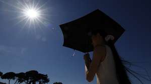 epa13080730 A woman shelters from the sun under an umbrella at Cap d'Antibes, southern France, 02 July 2026. Temperatures in Antibes reached up to 37 degrees Celcius as a spell of hot weather affected much of Europe.  EPA/SEBASTIEN NOGIER