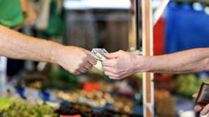 epa10843379 A customer pays for their purchase at a weekly market, in Essen, Germany, 06 September 2023. According to German government's statistics, food prices in July 2023 were on average 11 percent higher compared to the same period in 2022. German welfare organizations reported in 2022 that 13.8 million people in Germany lived in poverty or were at risk of being below the poverty line.  EPA/CHRISTOPHER NEUNDORF