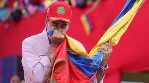 epaselect epa12563451 Venezuelan President Nicolas Maduro kisses a flag during a rally in Caracas, Venezuela, 01 December 2025. Maduro said that his country's power is based on the people, their guns, and their determination to build their homeland, at a time when tensions with the US have escalated due to the military deployment in the Caribbean and warnings about Venezuelan airspace, which have led to a wave of flight cancellations.  EPA/Miguel Gutierrez