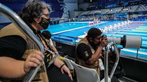 O fotógrafo Brasileiro João Maia (D), acompanhado pela sua guia e tradutora, Sandra Chammem (E), fotografa uma prova de natação no Centro Aquático de Tóquio, nos jogos Paralímpicos de Tóquio2020, Japão, 28 de agosto de 2021. (ACOMPANHA TEXTO DE 2 DE SETEMBRO DE 2021). MIGUEL A. LOPES/LUSA