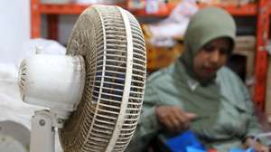 epa10630569 A resident uses a fan at Al Mahira traditional market in Banda Aceh, Indonesia, 16 May 2023. The Meteorology, Climatology and Geophysics Agency in Aceh has issued a warning to the public to reduce outdoor activities related to the heat wave caused by El Nino.  EPA/HOTLI SIMANJUNTAK