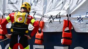 epa11403492 A member of the Italian Red Cross stands next to part of a banner made by the crew of Doctors Without Borders (MSF) search and rescue vessel &#039;Geo Barents&#039; by 11 white bags used to recover the bodies of dead migrants and life jackets with the words reading &#039;Europe...How many more?&#039;, to symbolize the bodies recovered at sea, upon arrival at the port of Genoa, Italy, 11 June 2024. Geo Barents ship docked at the port carrying 165 migrants, mainly from Eritrea, rescued in the Libyan area. Among the rescued migrants are 109 recovered onboard a rubber dinghy and 37 from a fiberglass boat. There are 33 minors on board, around thirty of whom are unaccompanied. While traveling towards Genoa, the ship recovered 11 bodies at sea for migrants who drowned in a previous shipwreck, before they were transferred to a Coast Guard patrol boat near Lampedusa.  EPA/LUCA ZENNARO