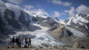 epa10113963 Tourists hike in front of the Bernina mountain group with the Pers and Morteratsch glaciers in Pontresina, Switzerland, 10 August 2022. The hot summer of 2022 is believed to set a new record in melting glaciers.  EPA/GIAN EHRENZELLER