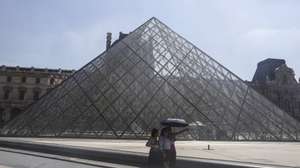 epa12206658 Tourists walk with umbrellas to protect themselves from the sun around the Louvre museum during a hot day in Paris, France, 30 June 2025. From 01 July, Paris and the entire Ile-de-France region, as well as 16 other departments, will be under red alert for extreme heatwave conditions, with temperatures expected to reach 36 to 40 degrees Celsius, with peaks of 41 degrees. This red alert level was last triggered in the Ile-de-France region in August 2020.  EPA/TERESA SUAREZ