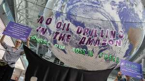 epa12535964 A group of people from the Eko community hold signs with messages calling for a halt to Brazilian oil company Petrobras' plans to explore near the mouth of the Amazon River during COP30 in Belem, Brazil, 19 November 2025.  EPA/FRAGA ALVES