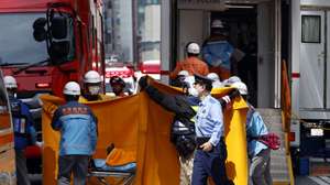 epa12992292 Emergency personnel deploy blankets to shield a person on a stretcher carried out of the Ginza Six luxury shopping complex in Tokyo's Ginza district, Japan, 25 May 2026. Authorities said there is information that a man allegedly sprayed a substance inside the building’s first floor, causing irritation to more than 20 people who complained of health issues including sore throats. Tokyo Metropolitan Police Department is investigating the cause.  EPA/FRANCK ROBICHON