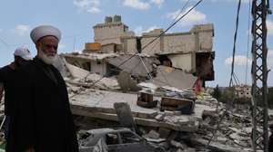 epa13039566 A sheikh who has returned to his village stands next to a destroyed building following an Israeli strike in the village of Maaroub, southern Lebanon, 15 June 2026, after the announcement of a US-Iran mediated preliminary framework to end regional military hostilities and lift the naval blockade on the Strait of Hormuz.  EPA/WAEL HAMZEH