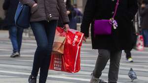 epa08890252 Shoppers walk with bags in the center of Milan as they shop ahead of the Christmas holidays in Milan, Italy, 17 December 2020.  EPA/ANDREA FASANI